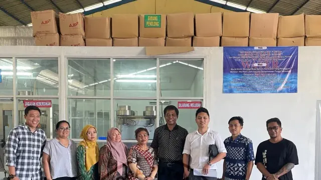 Tim Dua Putra bersama staf pabrik di depan gudang pabrik air minum dalam kemasan